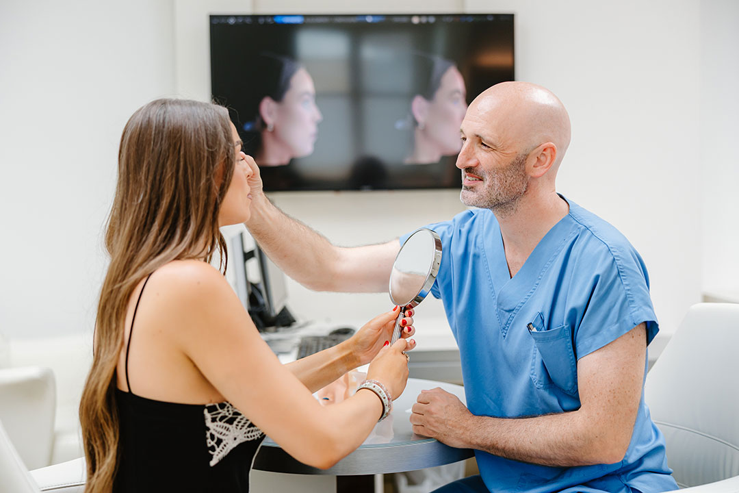 Dr. Christoph Grill untersucht in der Erstberatung die Augenpartie einer Patientin – Kuzbari Zentrum Wien